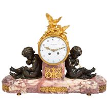 Louis XVI style mantel clock with bronze cherubs.